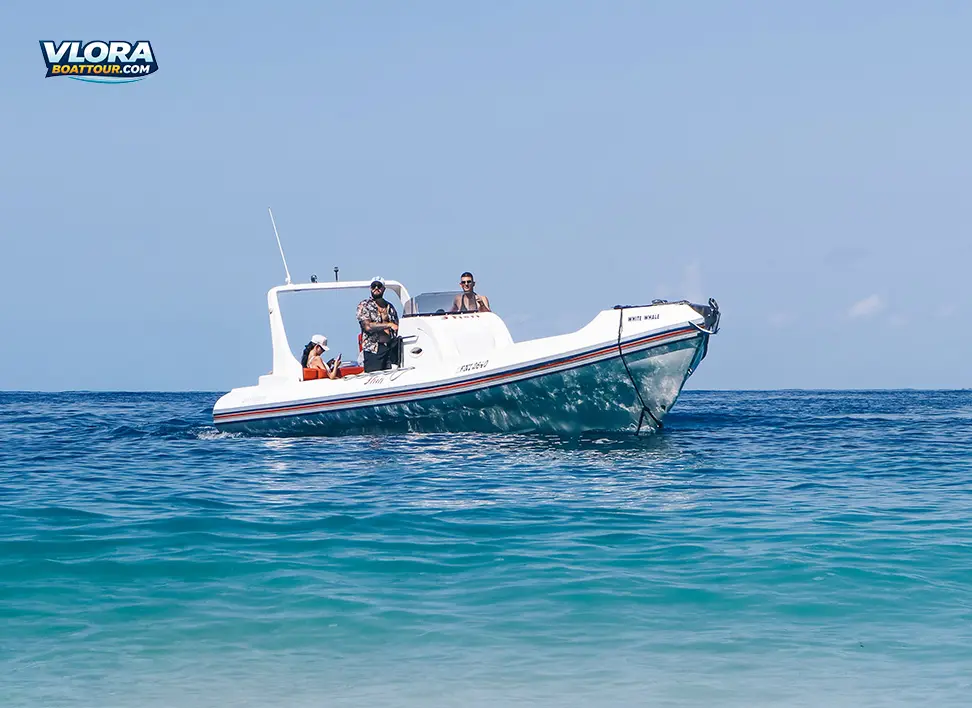 Private speedboat cruising on the open sea near Vlore, with passengers on board and clear blue water stretching to the horizon under a bright sky.